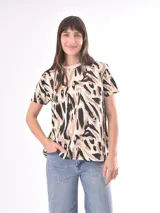 Remera de manga corta con estampado abstracto en tonos beige, marrón y negro.