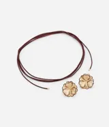 Conjunto de collar de cordón y caravanas con forma de flor con pétalos en capas y detalle en el borde, con baño de oro ligero.