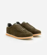 Championes de hombre de estilo retro, color verde oliva, con recortes en gamuza sintética, cierre con cordones y suela de goma con detalles en blanco y naranja.