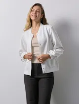 Campera bomber blanca con cuello a la base, abertura central con botones, bolsillos delanteros, ruedo y puños elastizados.