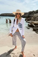 Camisa blanca de lino con bordado de pulpo azul en el pecho, de corte recto y manga larga.