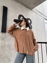 Campera marrón de pana con cierre frontal, cuello de piel sintética y bolsillos laterales.