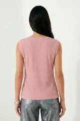 Top sin mangas color negro con textura plisada o arrugada y brillo sutil de lurex.