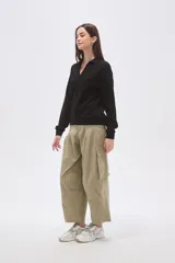 Buzo negro de manga larga con cuello polo y escote en V. Tiene un corte holgado y puños y dobladillo acanalados.