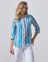 Blusa de gasa estampada con rayas verticales en tonos celeste, azul y blanco. Tiene cuello a la base con escote en V y abertura con botones. Las mangas largas son de largo regulable.