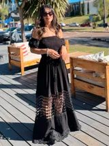 Vestido largo negro con escote off-shoulder, cuerpo elastizado tipo nido de abeja, mangas cortas con puntilla bordada y falda con paneles de encaje.