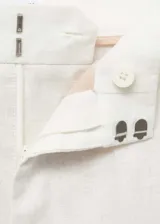 Pantalón de lino color crema, de corte recto y tiro alto, con trabillas para cinturón, bolsillos laterales y traseros.
