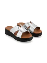 Sandalia plateada con capellada de cuero metalizado, suela anatómica, forro y plantilla de cuero, y suela de PU. Diseñada en Uruguay y fabricada en colaboración con Relaxshoe.