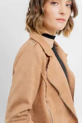 Chaqueta color beige de tela tipo gamuza con elastano, cuello solapa, manga larga con trabillas en hombro, bolsillos delanteros con cremallera metálica y cierre frontal con cremallera.