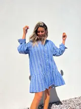 Vestido camisero corto celeste con bordado de flores blancas, corte recto y mangas largas.