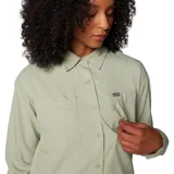 Camisa de senderismo color verde claro, de manga larga, con protección solar FPS 50, tejido que absorbe el sudor y neutraliza los olores, y ventilaciones de malla transpirable. Cuenta con tapeta abotonada con broches, bolsillo en el pecho con cierre a presión en el lado derecho, bolsillo en el pecho en el lado izquierdo con entrada lateral y cierre de velcro, y pequeño bolsillo en el lado interior derecho.