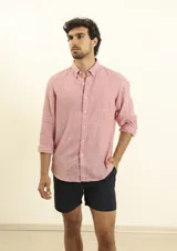 Camisa azul marino de lino y algodón, con cuello abotonado, manga larga con puños enrollados, bolsillo de parche en el pecho y cierre frontal con botones.