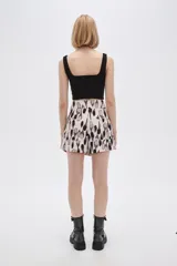 Short de poliéster con estampado abstracto en tonos beige, negro y gris. Tiene bolsillos delanteros con solapa y botón, y es de calce alto.
