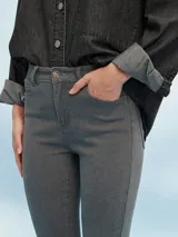 Pantalón jean skinny gris claro, tiro medio, con bolsillos delanteros y traseros.