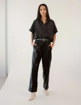 Pantalón de eco cuero negro, marca Elan. Con pretina elastizada, bolsillos delanteros, pierna recta y costura frontal.