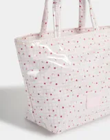 Lunchera tipo bolso con estampado escocés en tonos rosados y transparente. Tiene doble asa corta y etiqueta con logo en el frente.