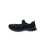 Zapatilla tipo Mary Jane color negro, con capellada de tela y tira con velcro sobre el empeine.