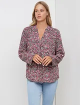 Blusa de manga larga con estampado floral pequeño en tonos rosados, morados y azules, escote en V y detalle de botones frontales.