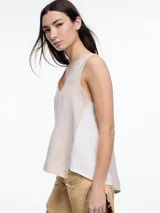 Top sin mangas color beige, confeccionado en lino, con escote en V y calce amplio. Presenta laterales en color blanco.