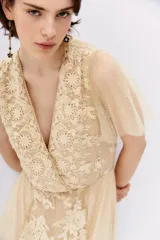 Vestido color crema con encaje floral, escote en V y mangas cortas de tul con lunares.