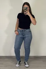 Pantalón jean mom celeste de tiro alto, corte holgado y tobillos ajustados.