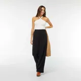 Camiseta de tirantes blanca con cuello halter cruzado y detalle de volados en el escote.