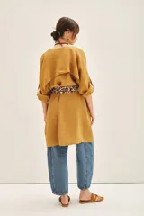 Saco color mostaza confeccionado en lino, de corte amplio y mangas largas. Incluye lazo estampado animal print.