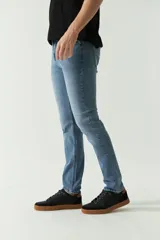 Jean clásico de hombre, de calce regular, con logo bordado, grifa de cuero y pasa cintos.