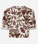 Blusa tipo t-shirt de corte super cropped con cuello redondo y mangas cortas. Presenta un estampado de íconos playeros en color marrón sobre un fondo beige.