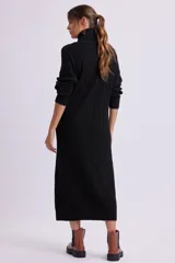 Vestido largo negro de punto canale con cuello alto y mangas largas.