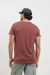 Remera verde militar de algodón con cuello redondo y manga corta. Estampado frontal con diseño de montañas y texto en color negro.