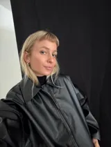 Campera negra de cuero sintético con cierre frontal y cuello clásico.
