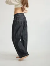 Pantalón de lino color beige con bordado artesanal de líneas onduladas en color marrón.