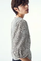 Blusa de tejido liviano con estampado de leopardo en blanco y negro. Modelo entallado con cuello redondo, cierre de botones y mangas globo tres cuartos con puños elásticos.