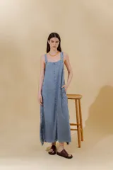 Vestido largo de jean celeste con breteles anchos, corte recto y bolsillos laterales.