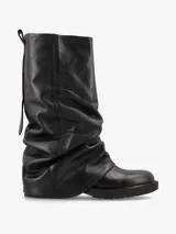 Bota de caña media de cuero negro suave, con diseño fruncido y silueta relajada. Presenta una base baja con suela resistente.