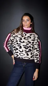 Sweater de punto con estampado animal print en tonos beige y negro, cuello alto tejido en color borgoña con detalle de línea rosa, mangas largas con detalle de dos líneas verticales en color borgoña y rosa.