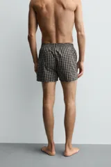 Calzoncillo tipo bóxer confeccionado en popelín de algodón con estampado a cuadros y cintura elástica.