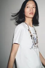 Camiseta blanca de algodón con cuello redondo y mangas cortas. Estampado frontal con la frase "Paris, Mon doux rêve!" en azul marino.