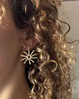 Par de aros colgantes de metal dorado con forma de sol. Cada aro tiene dos soles, uno más pequeño arriba y otro más grande abajo.