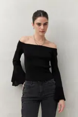 Top tejido negro con escote off shoulder y mangas largas acampanadas con terminación trabajada.