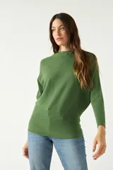 Sweater verde de punto liviano con textura acanalada y diseño de hombros caídos.