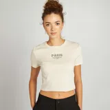 Camiseta corta color crema con estampado frontal de la palabra "Paris" en color verde.