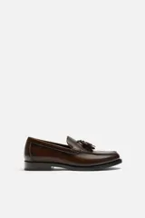 Mocasín de vestir color marrón oscuro, con detalle de borlas en la parte delantera.