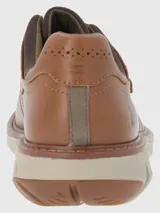 Zapato de cuero color marrón claro con ajuste de velcro y suela de goma color crema.