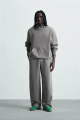 Pantalón jogger wide fit negro confeccionado en tejido de algodón con interior rizo. Pernera ancha, cintura elástica ajustable con cordón interior, bolsillos laterales y bolsillo trasero de plastrón.