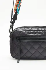 Bandolera negra de nylon matelassé con correa larga regulable y correa corta desmontable de cordones trenzados multicolores. Tiene cierre superior, bolsillo frontal con cierre, bolsillo trasero y dos bolsillos internos.