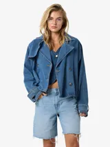 Campera de denim corta color celeste, con cuello tipo biker, cierre cruzado con doble hilera de botones y diseño sin forro.