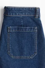 Short de denim azul de tiro alto con bolsillos delanteros y traseros. Cierre con botón y cremallera.
