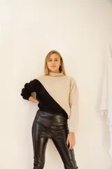 Sweater de punto color crema y mostaza, con cuello cisne y diseño asimétrico.
